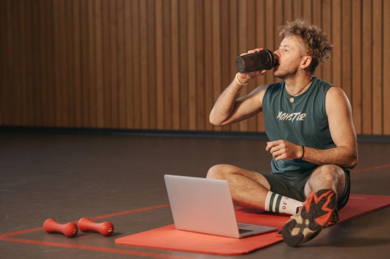 Man som dricker protein på gym